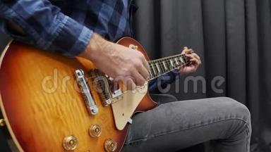 人类用吉他演奏。 专业音乐家吉他手在现代音乐工作室用电吉他表演抒情独奏。 吉他